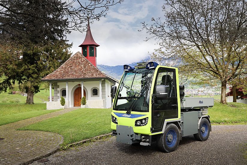 Elektrifiziertes Kommunalfahrzeug der Viktor Meili AG vor einer Kapelle